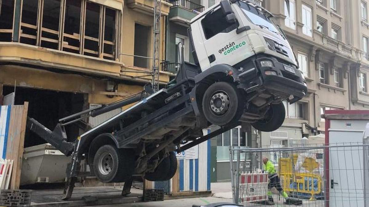Parte delantera del camión suspendida en el aire al descargar un contenedor.