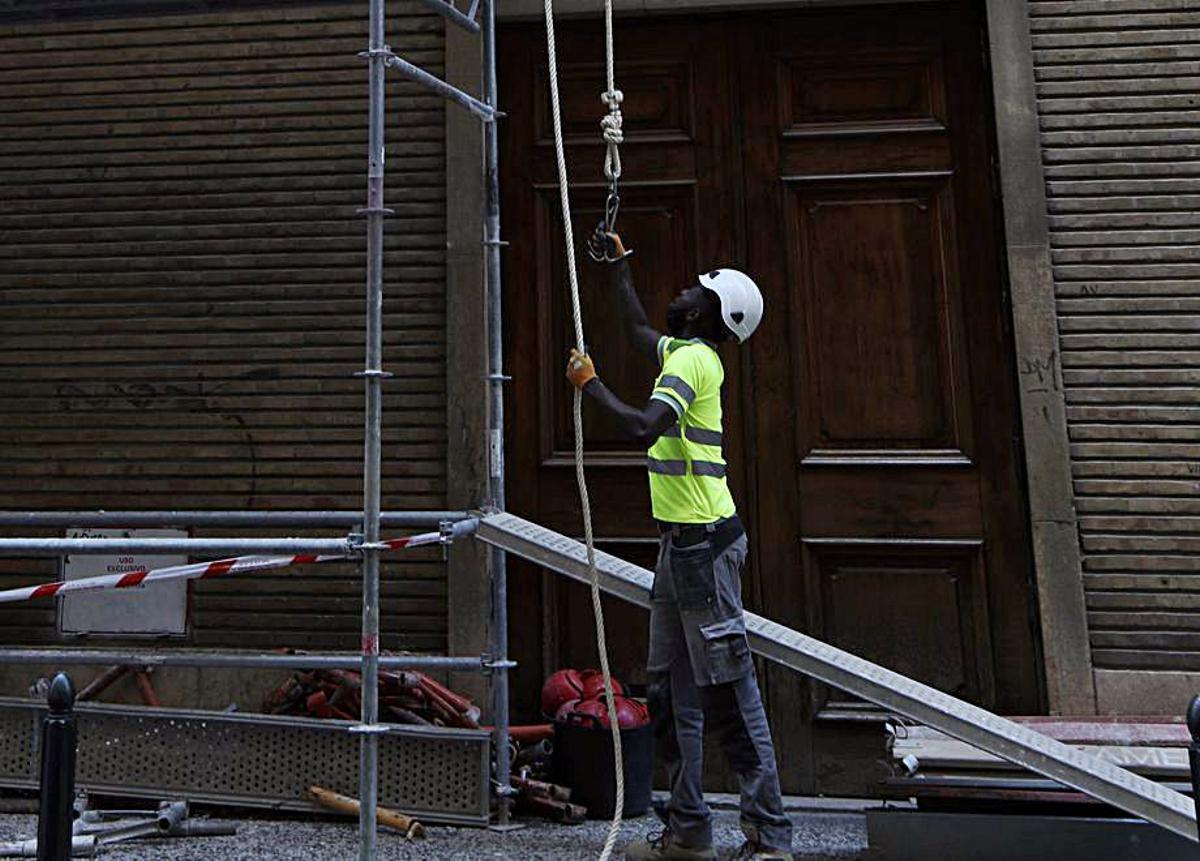 Un trabajador en Zaragoza realiza tareas junto a un andamio. | ANDREEA VORNICU