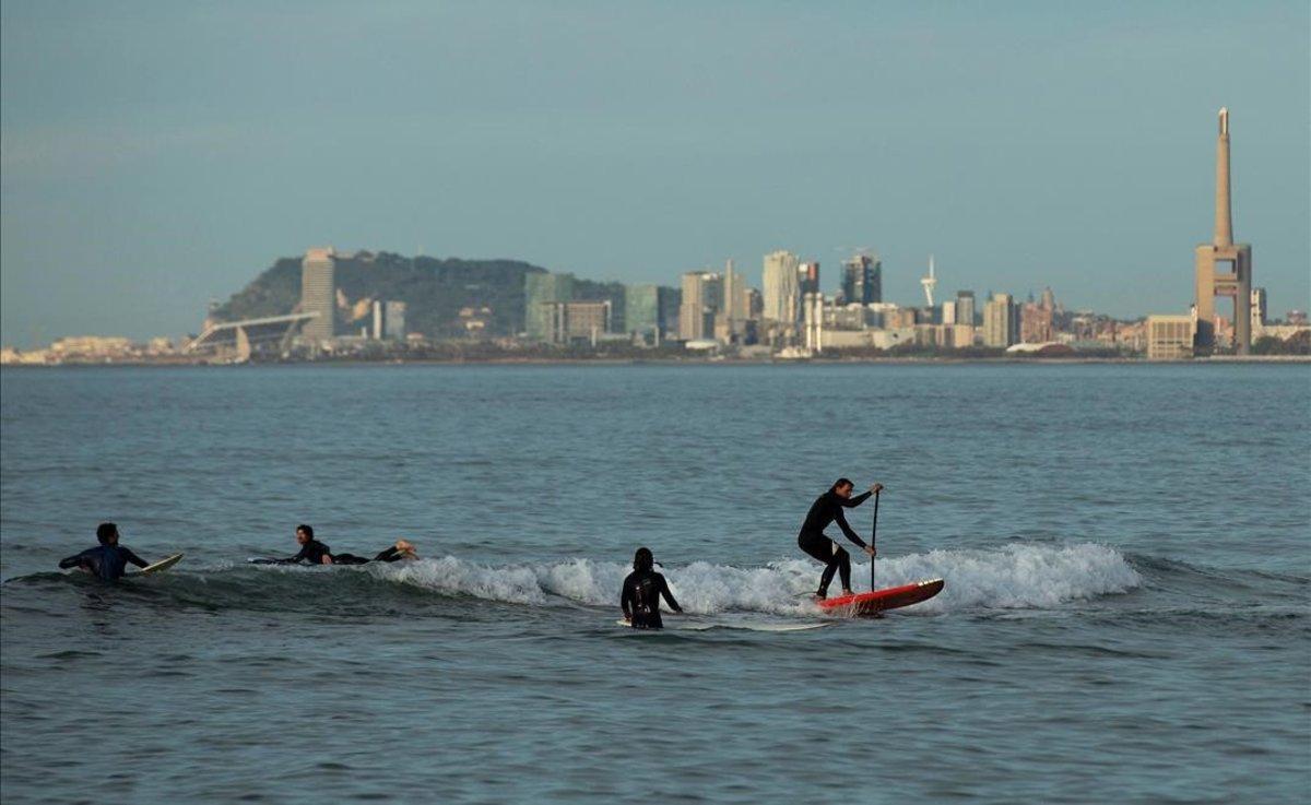 Ciudadanos practican surf en el Maresme, a primera hora de la mañana.