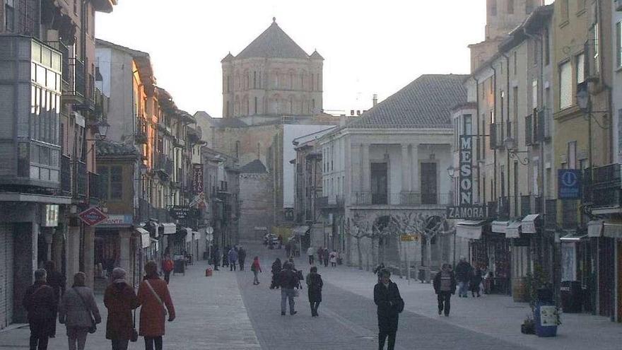 Vecinos pasean por la Plaza Mayor de Toro, con el Ayuntamiento y la Colegiata al fondo.