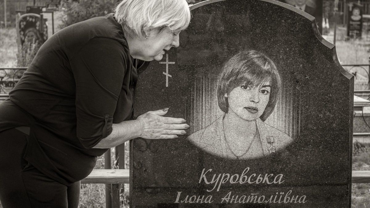 Iryna, madre de Ilona Kurovska, junto a la tumba de la activista ucraniana, en una de las imágenes de la muestra 'Retratos de fortaleza'.