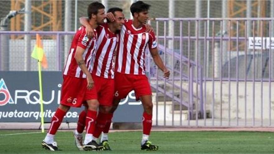 A la foto superior, Jofre Mateu, que va debutar, pugnant amb un rival. A la de sota, Chus Herrero, David García i Tébar celebrant un gol.