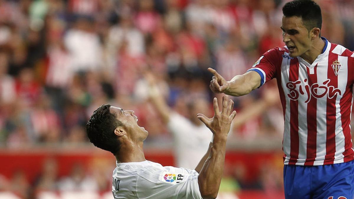 Cristiano pide penalti ante la mirada de Isma López, en Gijón