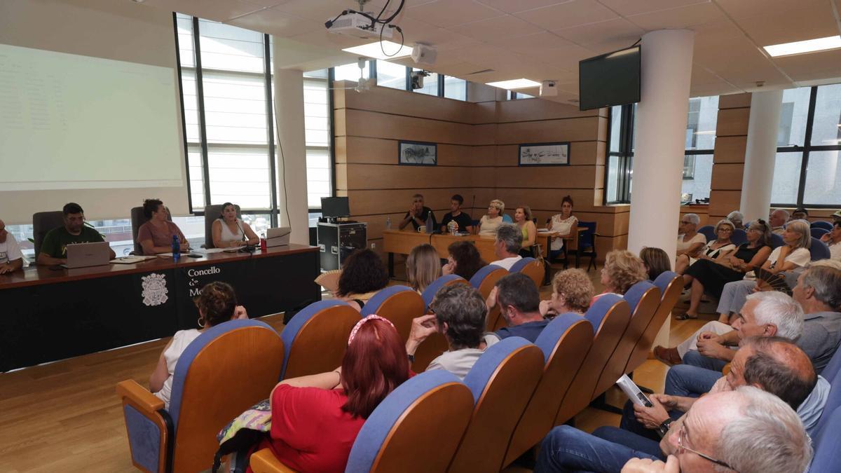 La alcaldesa (primera dcha.) en la mesa durante la asamblea vecinal en el salón de plenos.