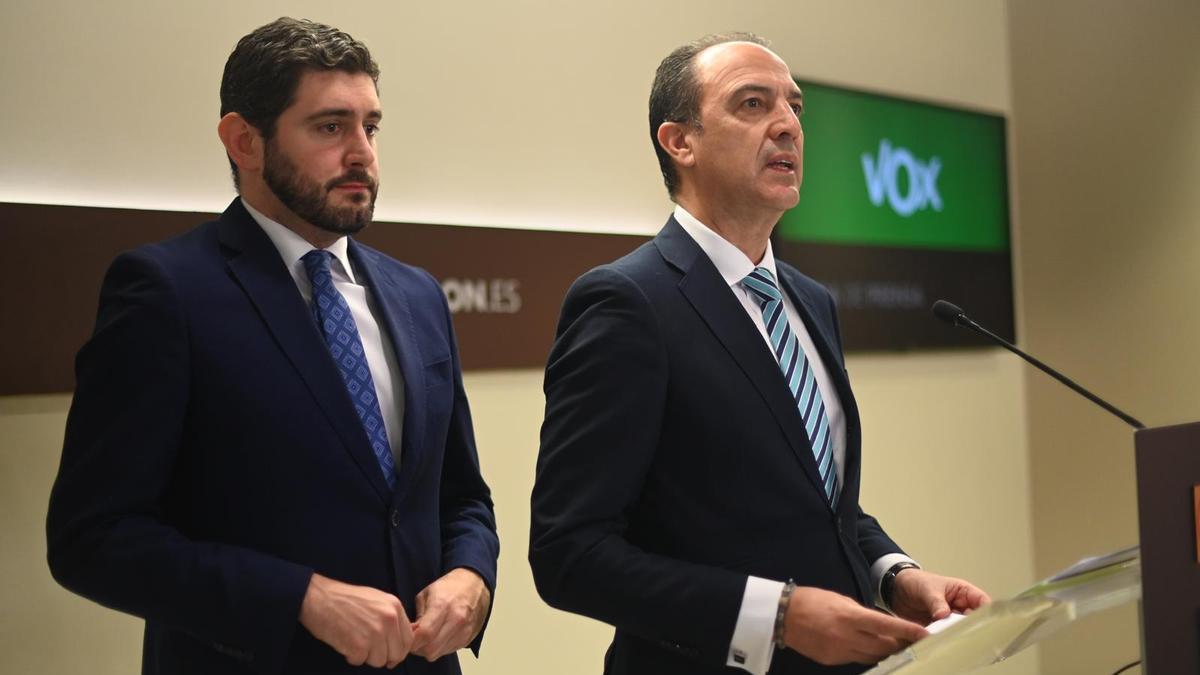 El consejero de Sanidad, José Luis Bancalero, junto a Alejandro Nolasco, portavoz de Vox, en la sala de prensa de las Cortes, con la cartela de Vox.