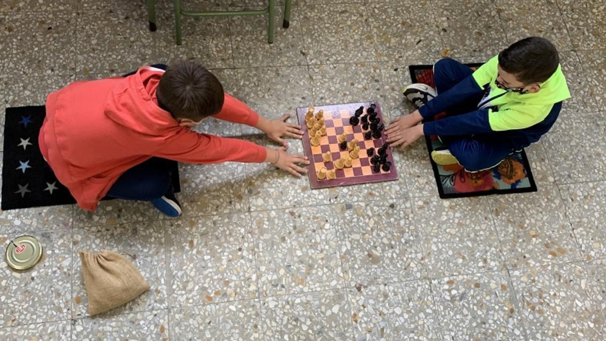 Alumnos jugando al ajedrez, con la distancia necesaria.
