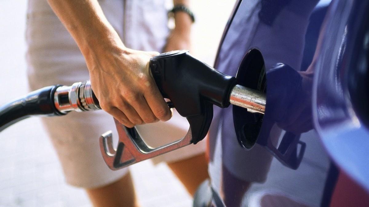 Un hombre pone gasolina en su coche.