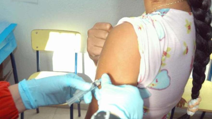 Un médico administra una vacuna a una niña. / efe