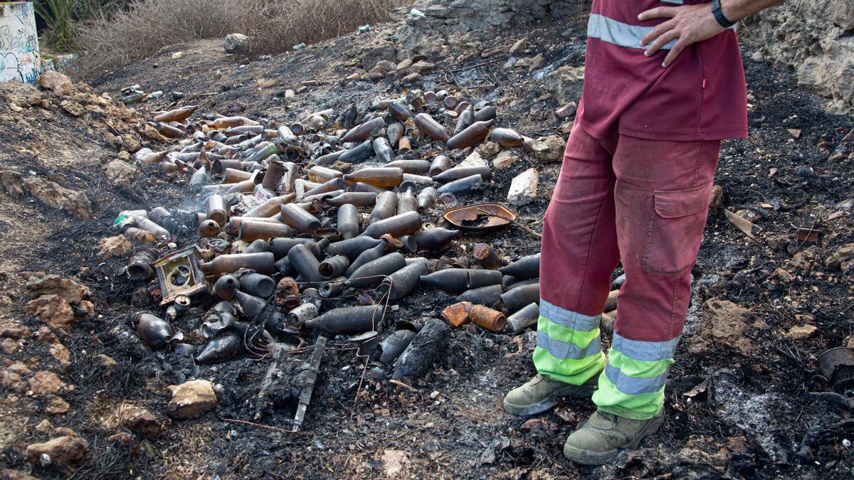 Restos de botellas en la zona incendiada junto a El Palmeral.