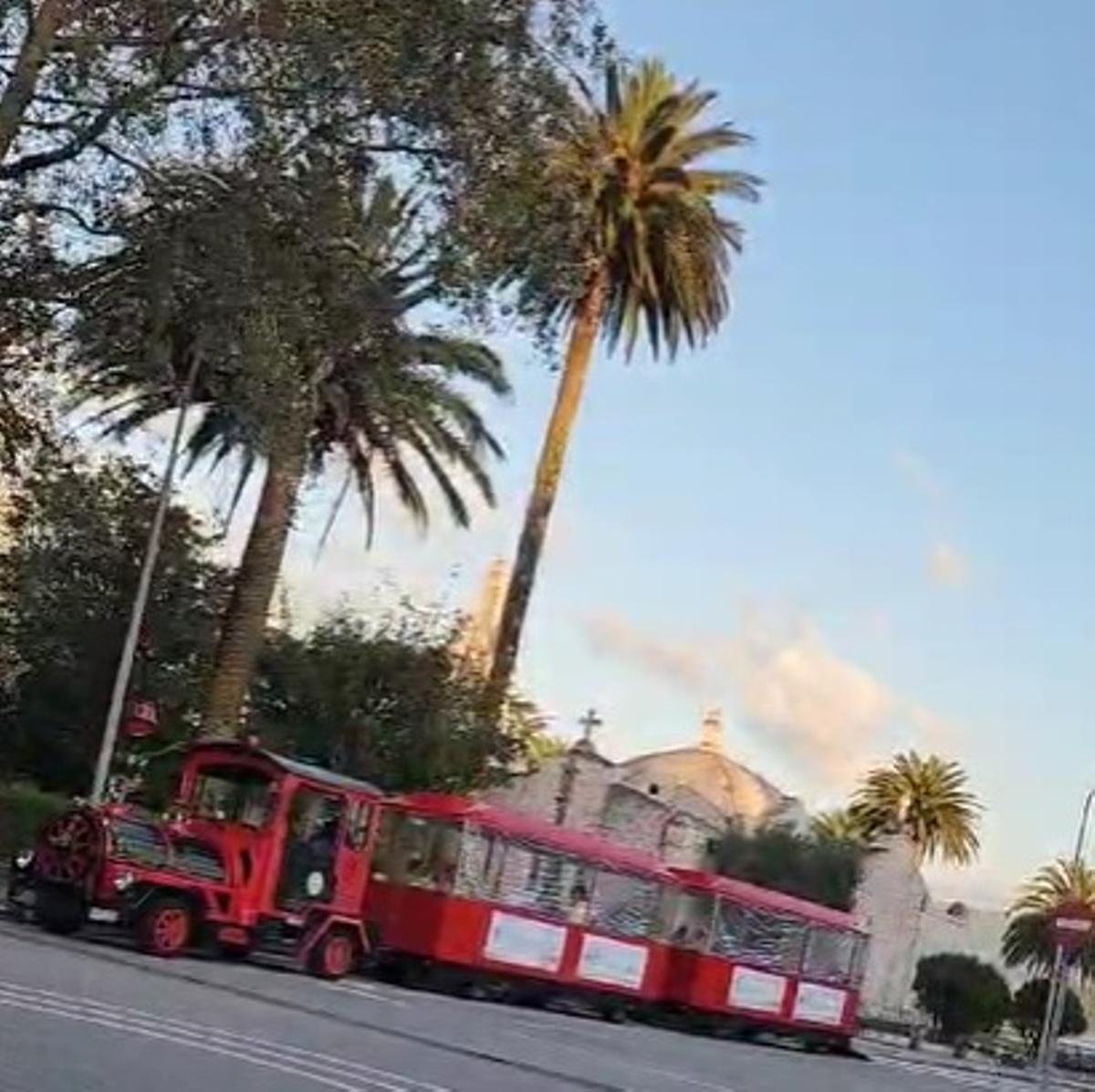 El tren turístico, estacionado ante la capilla de conchas.