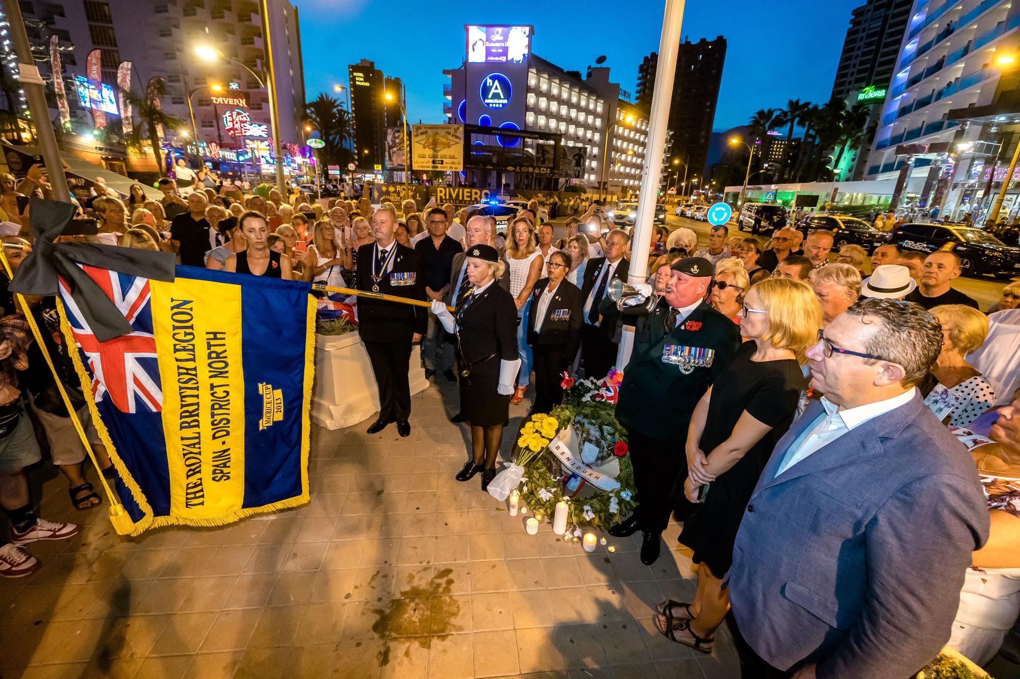 Británicos residentes y turistas de Benidorm rinden un sentido homenaje a Elizabeth II en el espacio habilitado por el Ayuntamiento en la zona inglesa de la ciudad.