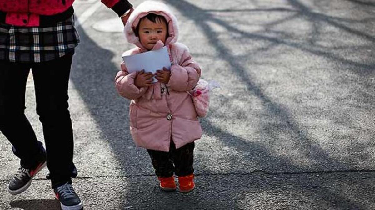 Una dona passeja amb una nena a Pequín. La població xinesa ha arribat als 1.340 milions d’habitants, segons l’oficina nacional d’estadística.