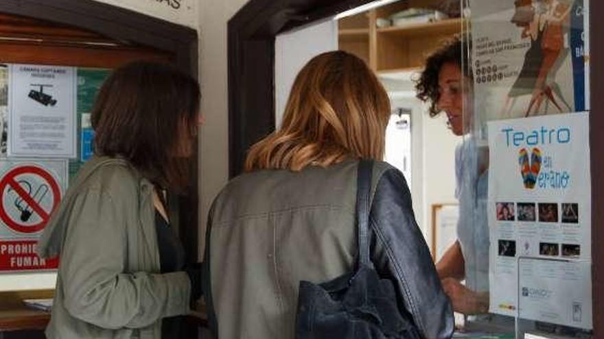 Dos visitantes, con chubasquero, en la Oficina de Turismo de Oviedo.