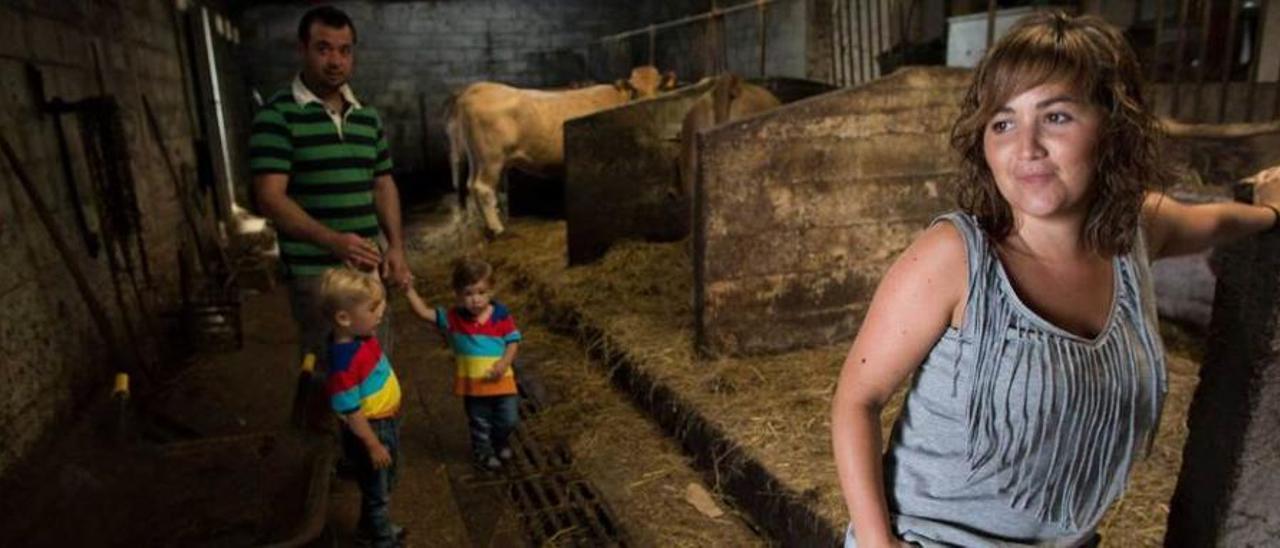 Tamara Fernández, en la cuadra de su ganadería; detrás, su marido, José Ramón Heres, con sus dos hijos, Borja y Raúl.