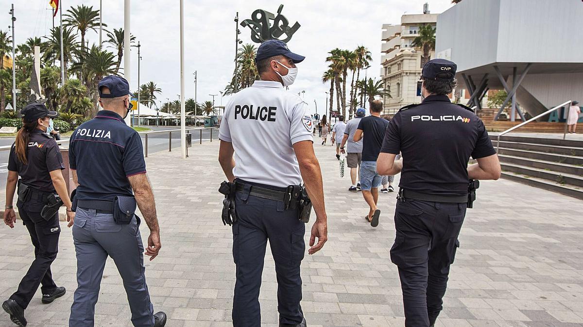 Efectivos de la Policía Nacional con dos agentes de Italia y Francia, el pasado jueves, junto a la plaza del Mar en Alicante. | ALEX DOMÍNGUEZ