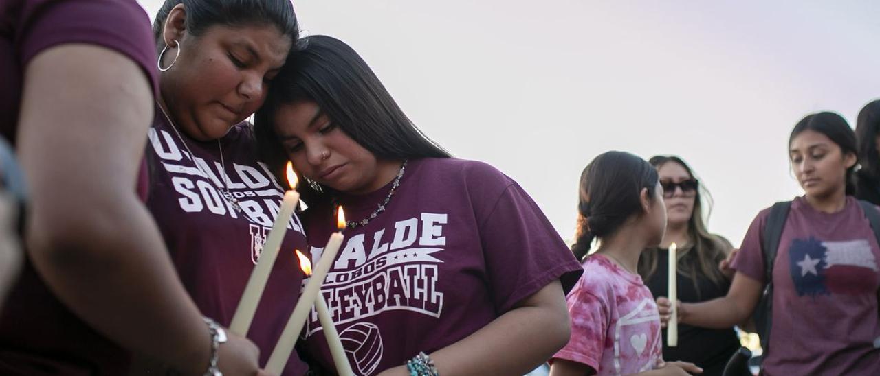 Vecinos de Uvalde se consuelan durante una vigilia con velas celebrada en el Fairplex Arena.