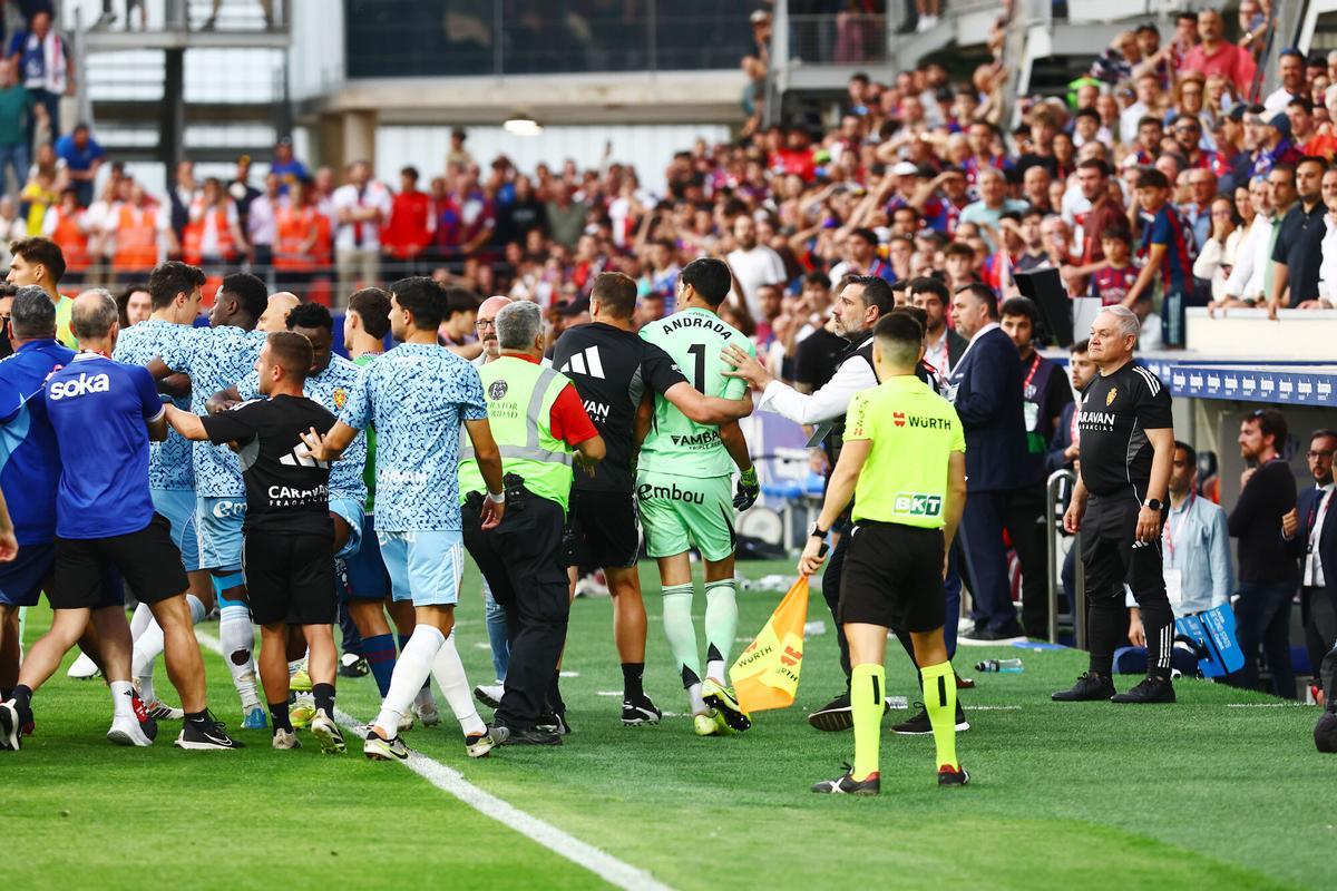 Varios miembros del cuerpo técnico del Real Zaragoza se llevan a Andrada hacia el túnel de vestuarios tras la agresión.