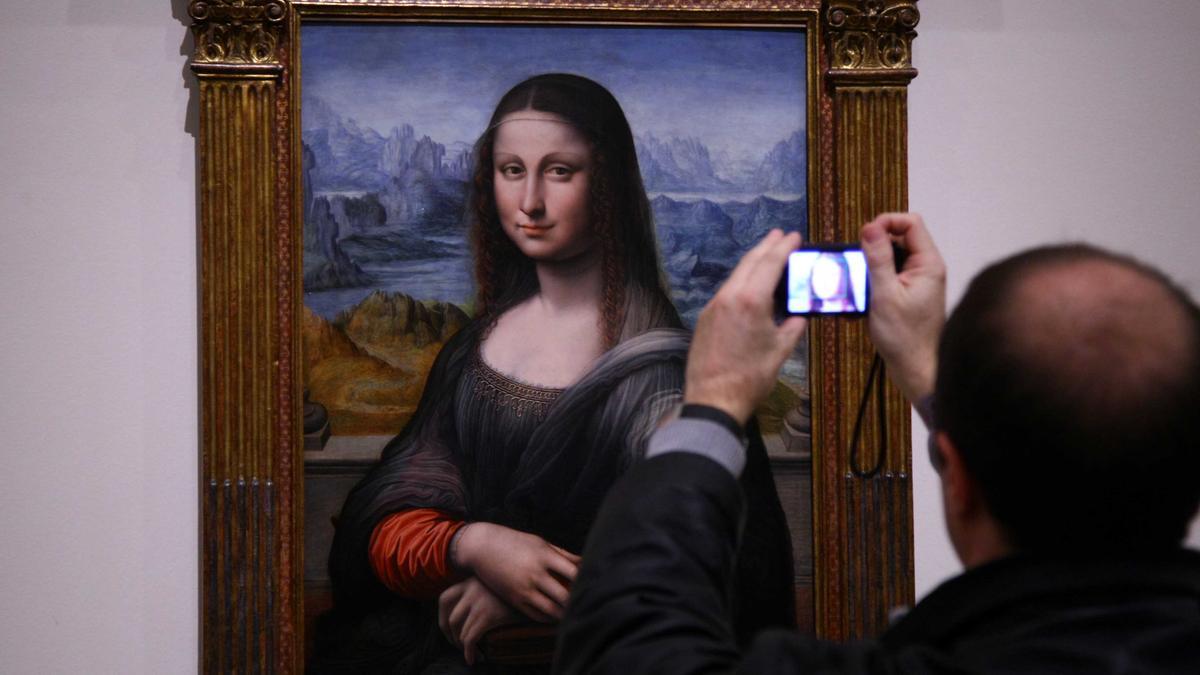 Un visitante del Prado fotografía la copia de la 'Mona Lisa' que hay en el Prado, la más antigua que se conserva.