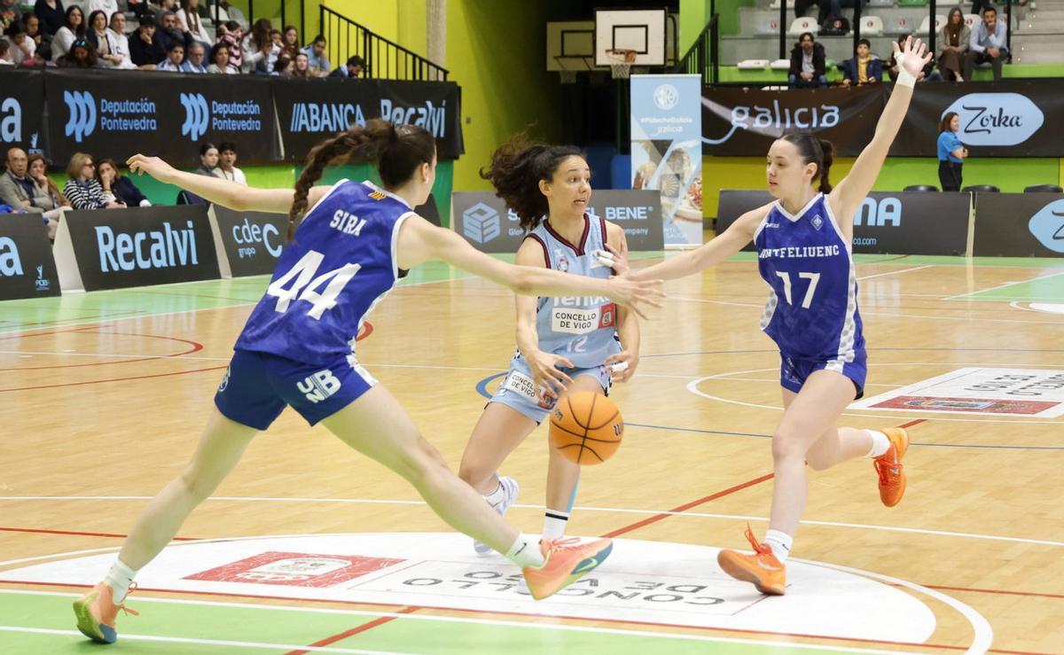 Marina Gea pasa el balón entre dos jugadoras rivales. | MARTA G. BREA
