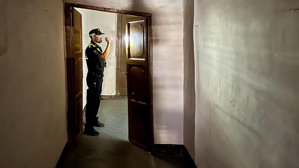Foto de archivo de un policía inspeccionando una vivienda ocupada en el centro de Mataró
