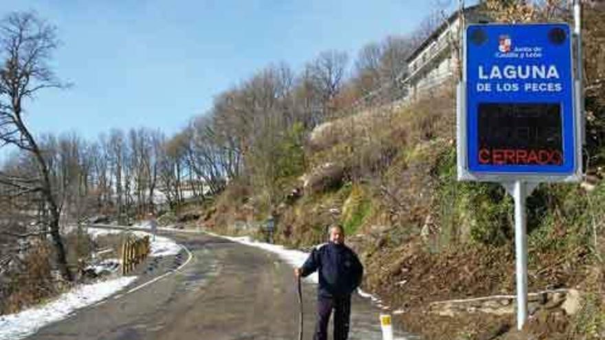 Un hombre al lado del nuevo panel informativo situado al inicio de la carretera de Peces.