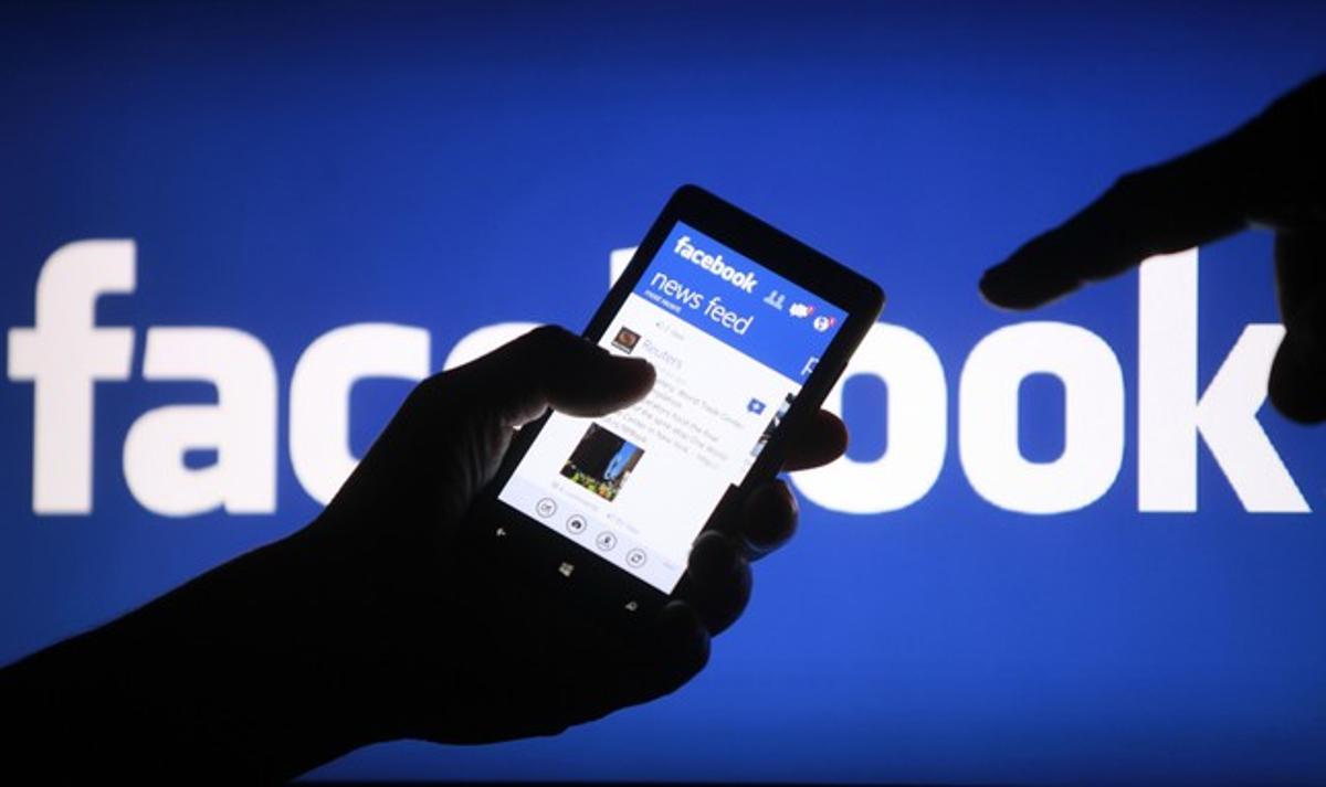 Un usuari utilitza Facebook des d’un ’smartphone’.