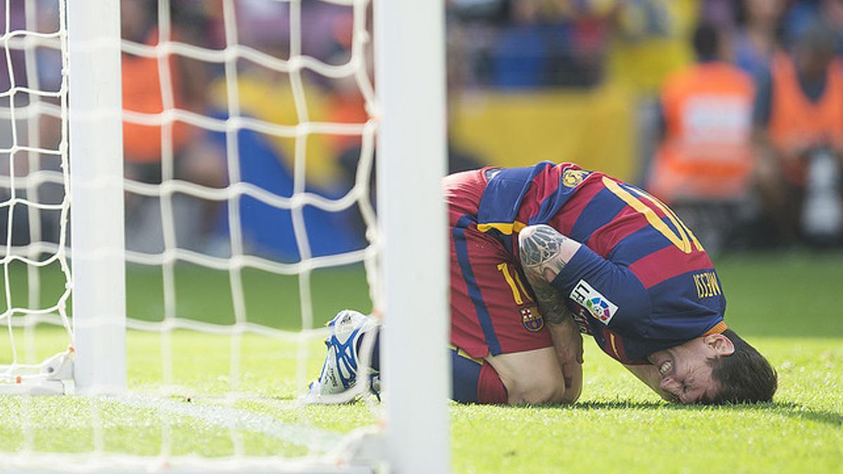 Leo Messi se duele en el césped del Camp Nou tras recibir un golpe en la rodilla izquierda, antes de abandonar el terreno de juego.
