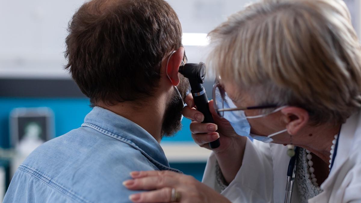 Un doctor revisa la audición de un paciente.