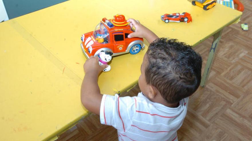 Un niño se entretiene con un coche de juguete.