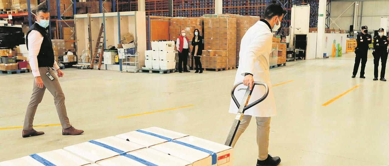 Un operario transporta unas cajas con las vacunas de Pfizer en las instalaciones de la distribuidora Bidafarma.