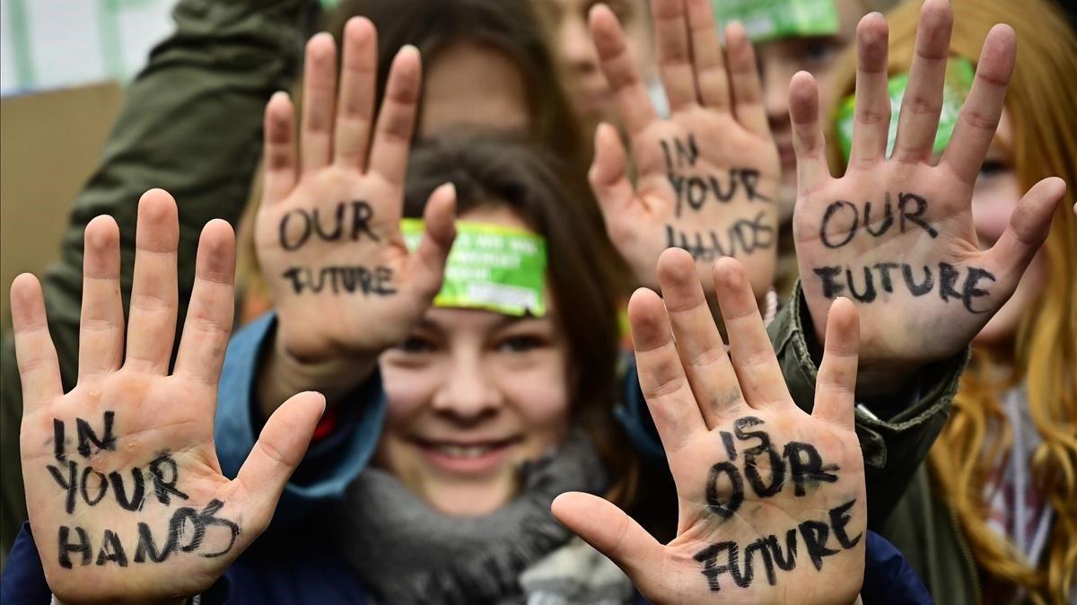 Jóvenes berlineses muestran el lema  Nuestro futuro en tus manos durante el movimiento Viernes para el Futuro.