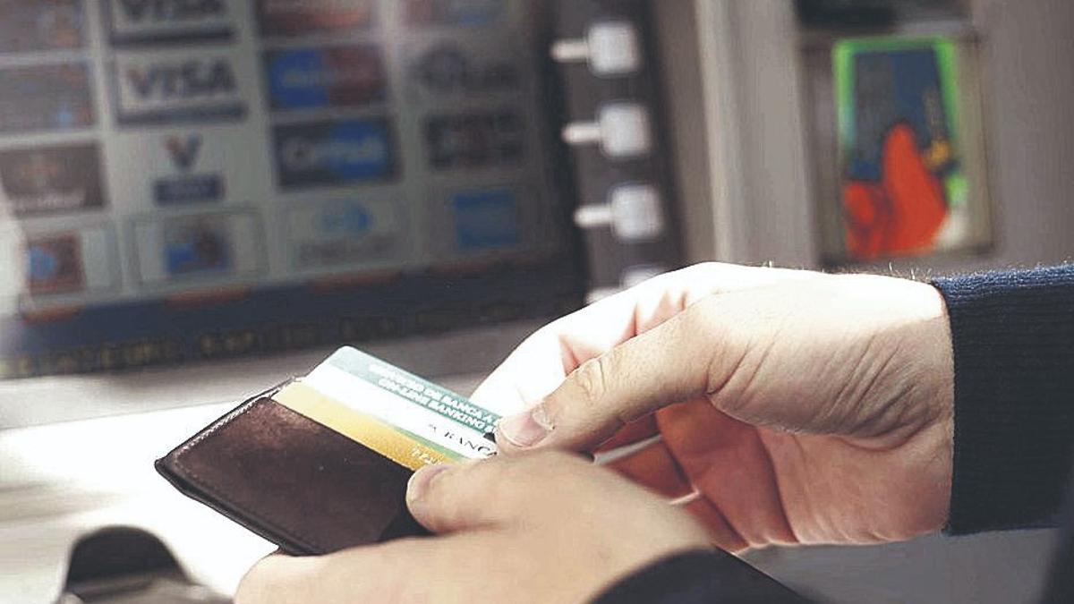 Una persona saca dinero de un cajero.