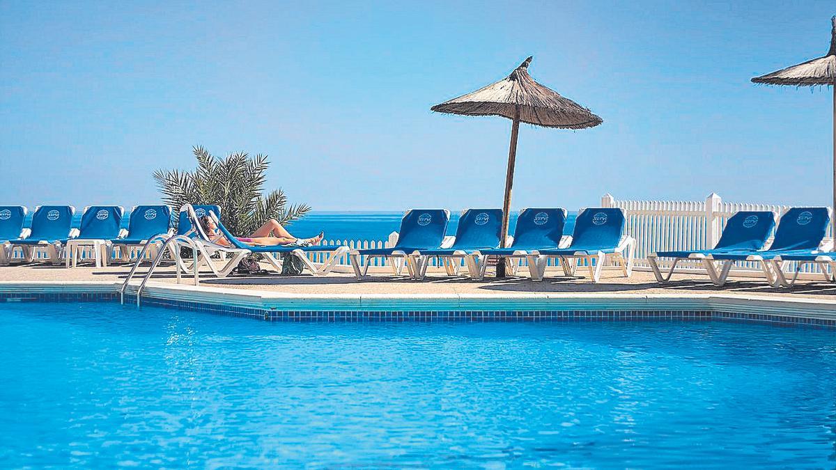 Una turista toma el sol en la piscina del hotel La Zenia  de Orihuela.