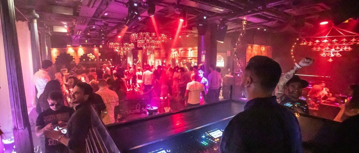 Jóvenes se divierten por la noche en una discoteca, en una fotografía de archivo.