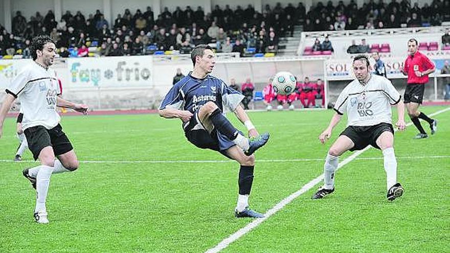 Javi López controla el balón entre los caudalistas Javi, a la izquierda, y Fidalgo en un encuentro en el Hermanos Antuña.