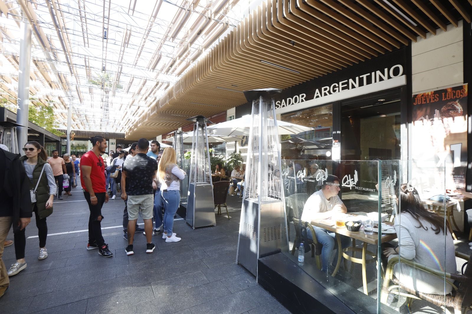 Mucha gente pero pocas bolsas en los comercios en una nueva apertura en festivo