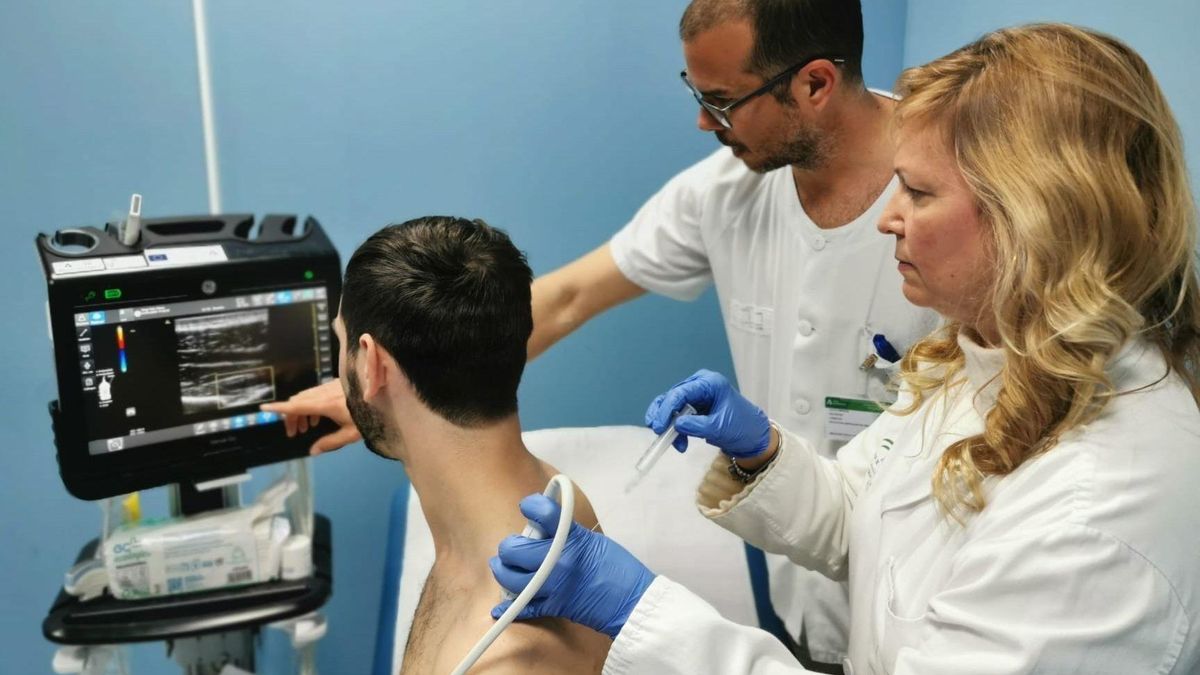 Una médico atiende a un paciente en el servicio de Medicina Física y Rehabilitación del Hospital de Valme.