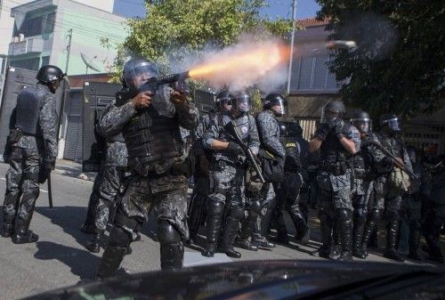 A policeman shoots tear gas during a demonstration against the 2014 World Cup in Sao Paulo