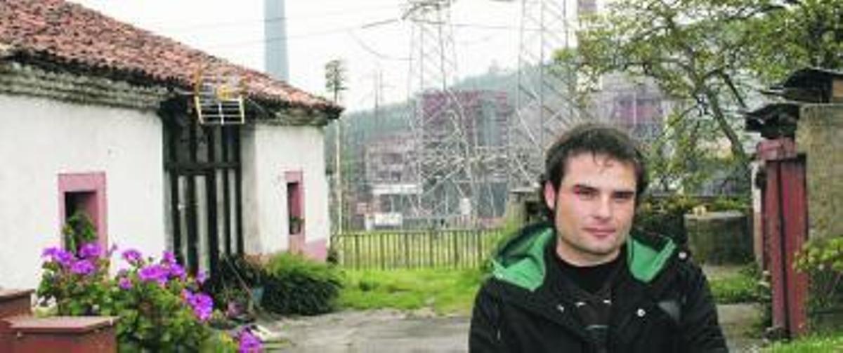 Pablo Quiroga, junto a su casa, en Carrió, con la subestación eléctrica detrás.