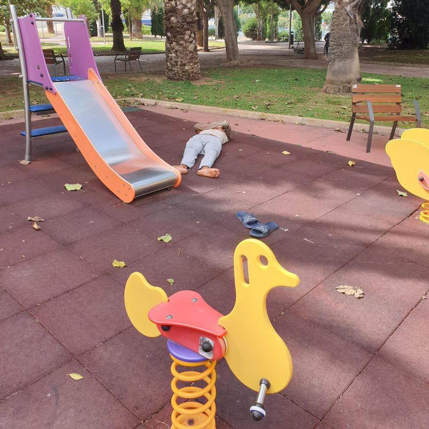 Un &#039;sin techo&#039; afectado por el consumo de alcohol durmiendo en la zona de columpios del parque a plena luz del día