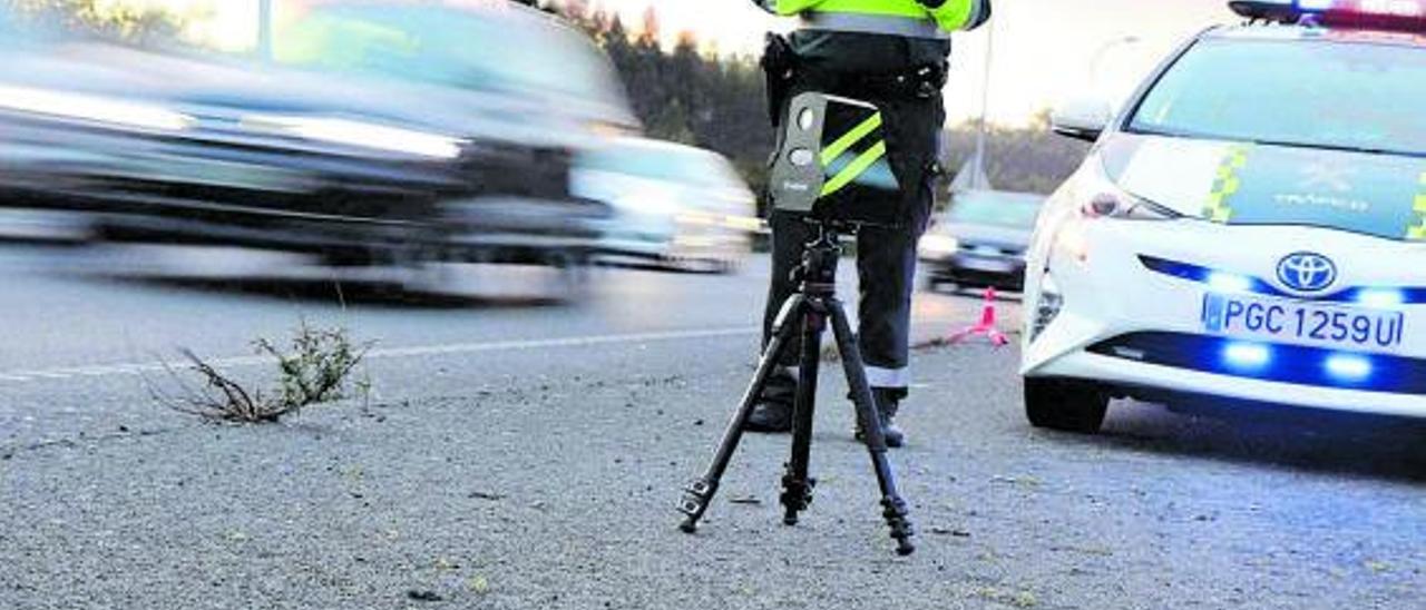 Un agente durante un control de velocidad con el mini radar Velolaser. | // GUARDIA CIVIL