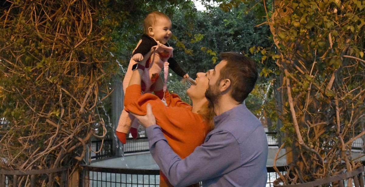 Luisa María Oliver y Domingo Vera, junto a su hija Helia, de sólo trece meses, en un parque infantil de Murcia.  | ISRAEL SÁNCHEZ