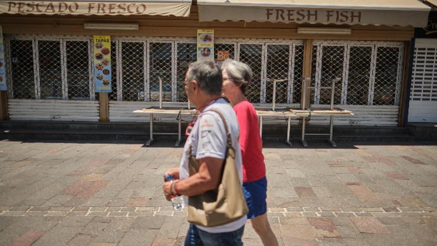 Una pareja pasea, ayer, ante un restaurante cerrado en el sur de Tenerife.