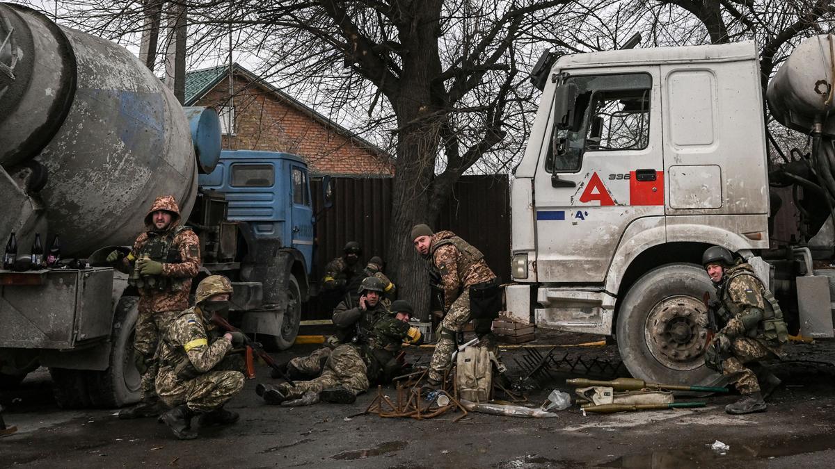 Los militares ucranianos se protegen de los bombardeos en la ciudad de Bucha, al oeste de Kiev