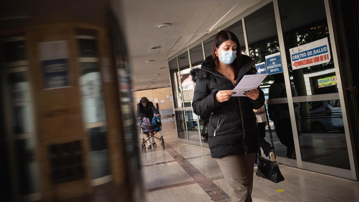 Una mujer con mascarilla a las afueras del centro de salud Doctor Guigou.