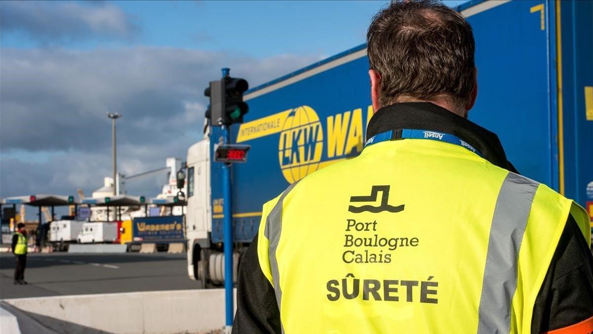 Un empleado de seguridad del puerto de Calais observa un camión.