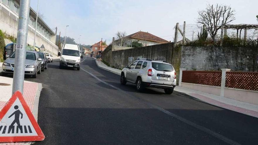 Vehículos circulando sobre el nuevo asfalto, ayer, junto al colegio público de Castrillón. // G.Núñez