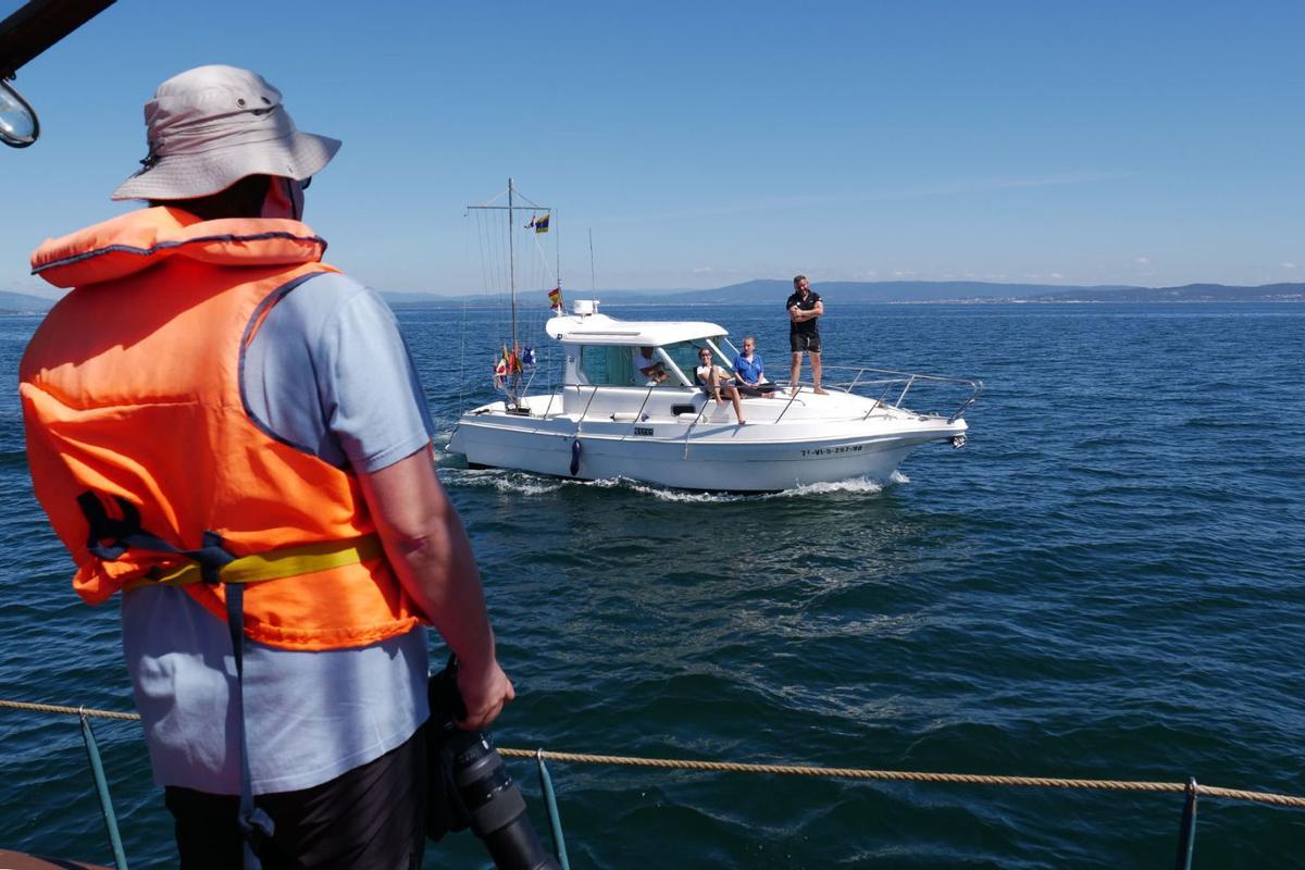 Uno de los participantes en la expedición conversa con los tripulantes de una embarcación de recreo.