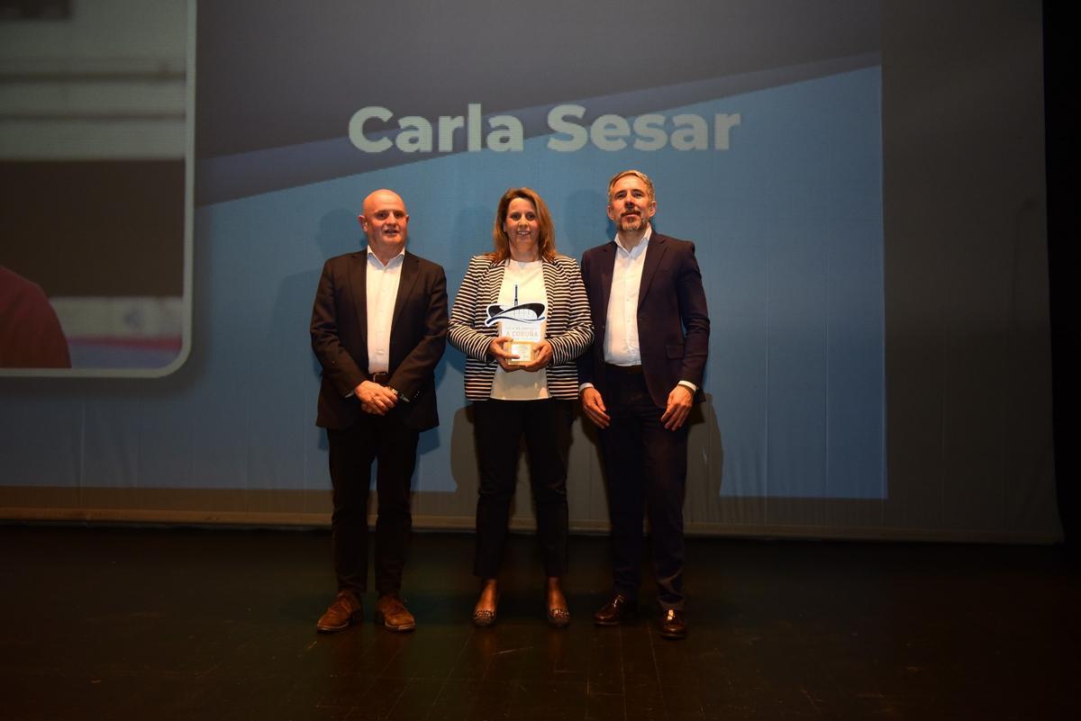 Inmaculada Díaz, madre de Carla Sesar, recoge el premio de mano con Francisco Duarte, director de Personas de Vegalsa, y Pedro Costa, gerente general de Prensa Ibérica en Galicia