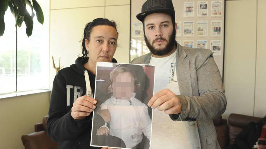 La abuela y el tío de la pequeña Mª Dolores muestran una foto de la menor, ayer en LA OPINIÓN.